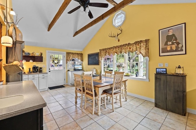 dining room featuring beam ceiling, high vaulted ceiling, ceiling fan, light tile patterned flooring, and baseboards