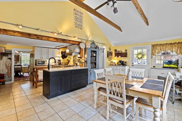 dining area featuring beam ceiling, plenty of natural light, light tile patterned flooring, a ceiling fan, and high vaulted ceiling