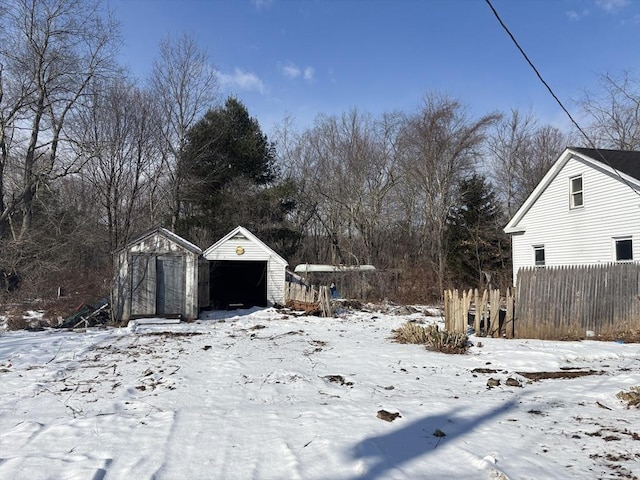 yard layered in snow with a shed and a garage