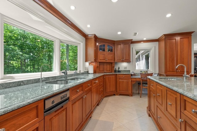 100 Parmenter Rd, Framingham, MA 01701 - kitchen featuring brown cabinetry, stone countertops, crown molding, recessed lighting, and light tile patterned floors