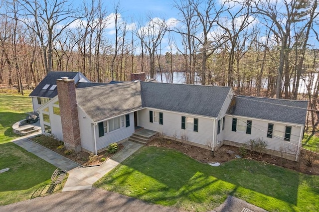 100 Parmenter Rd, Framingham, MA 01701 - view of front of home with a chimney, a shingled roof, a front yard, and a water view