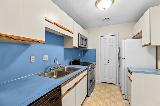 kitchen featuring white cabinets, sink, appliances with stainless steel finishes, and light tile patterned floors