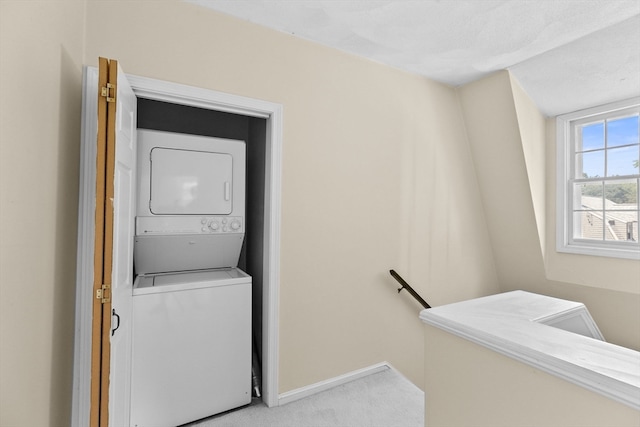 laundry area featuring carpet flooring and stacked washer / drying machine