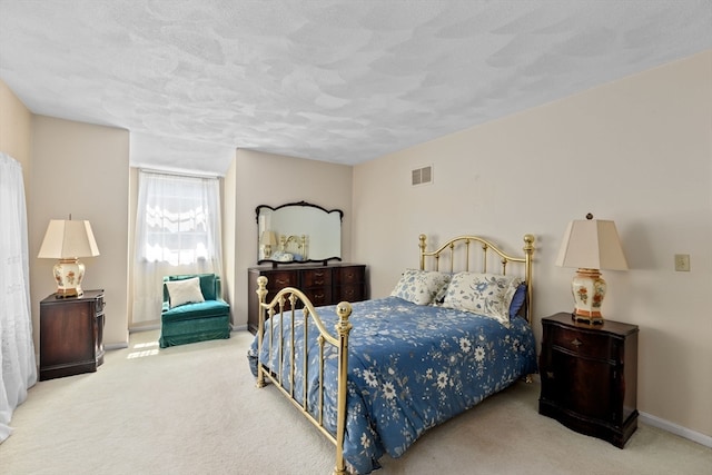 bedroom with a textured ceiling and light colored carpet