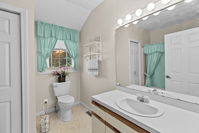 bathroom featuring vanity, toilet, and vaulted ceiling