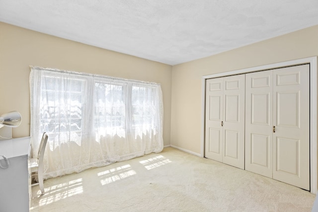 unfurnished bedroom with a closet and light colored carpet