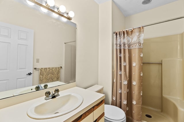 bathroom with curtained shower, vanity, and toilet