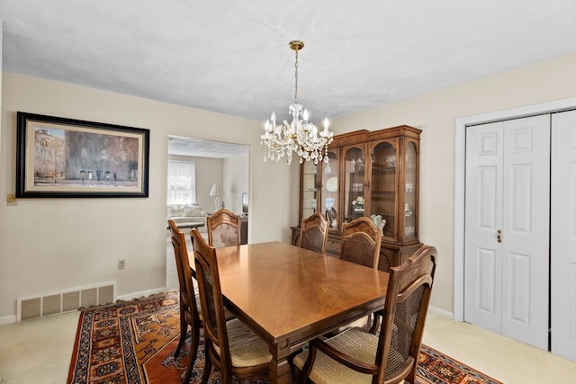 carpeted dining area featuring a notable chandelier