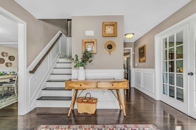 interior space with a wainscoted wall, wood finished floors, and a decorative wall