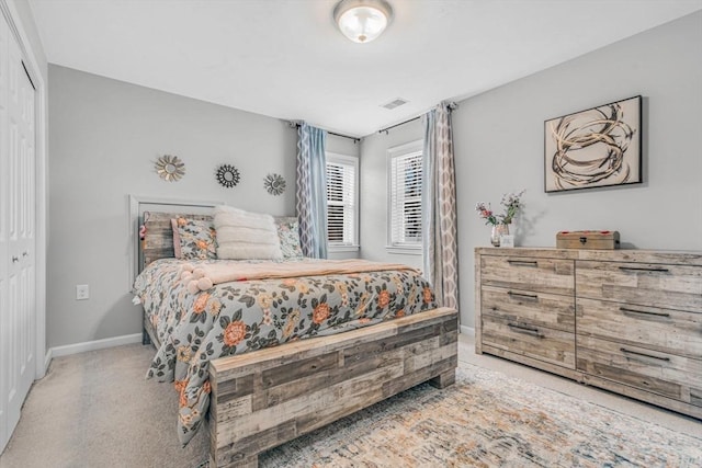 bedroom featuring carpet flooring, baseboards, visible vents, and a closet