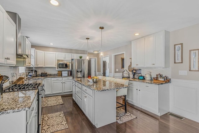 kitchen with visible vents, light stone countertops, white cabinets, stainless steel appliances, and dark wood-style flooring