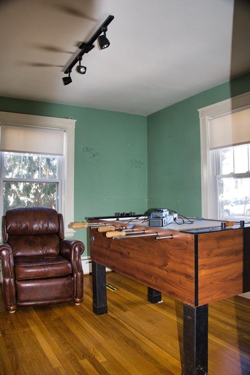 playroom with a baseboard heating unit and wood finished floors