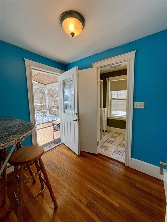 dining space with radiator, baseboards, and hardwood / wood-style flooring