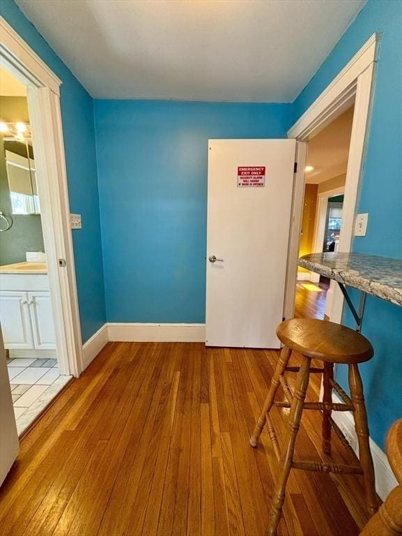 interior space featuring wood-type flooring and baseboards