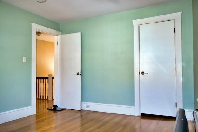 unfurnished bedroom featuring baseboards and wood finished floors