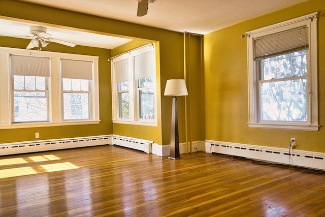 spare room featuring a baseboard radiator, ceiling fan, and wood finished floors