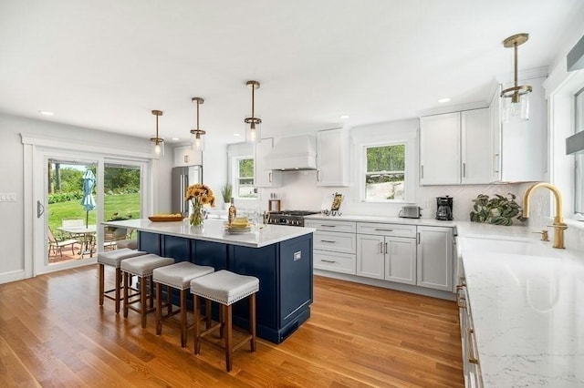84 S St, Rockport, MA 01966 - kitchen featuring custom range hood, a sink, a breakfast bar area, a center island, and stove