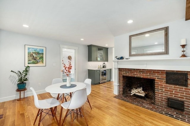 84 S St, Rockport, MA 01966 - dining room with wine cooler, light wood finished floors, a fireplace, baseboards, and recessed lighting