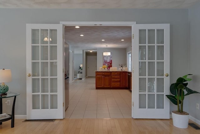 interior space with light wood finished floors, recessed lighting, visible vents, and baseboards