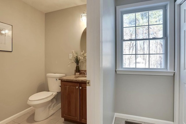 bathroom with tile patterned flooring, plenty of natural light, vanity, and toilet