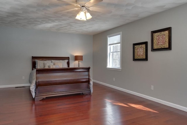 bedroom featuring a ceiling fan, baseboards, and wood finished floors