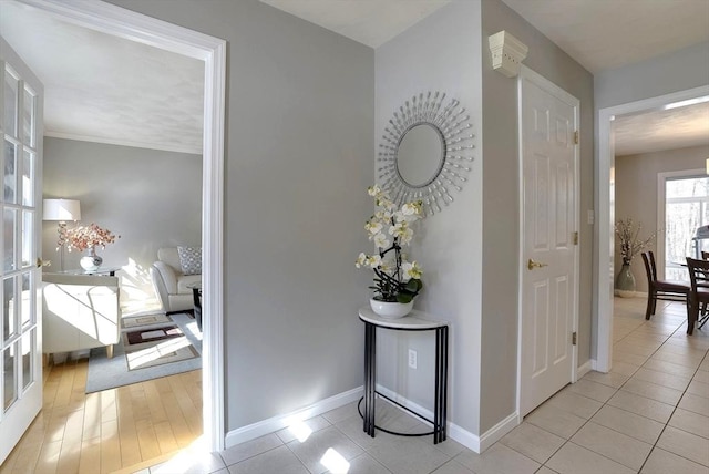 hall with light tile patterned flooring and baseboards