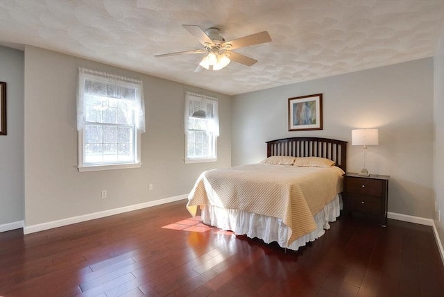 bedroom with a ceiling fan, dark wood-style flooring, and baseboards