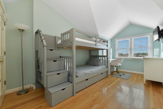 bedroom featuring light wood-type flooring and vaulted ceiling