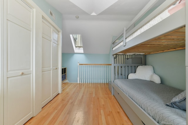 bedroom featuring a closet, light hardwood / wood-style floors, and a skylight