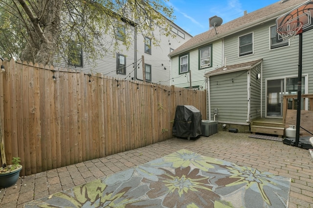 view of patio featuring central air condition unit and a grill