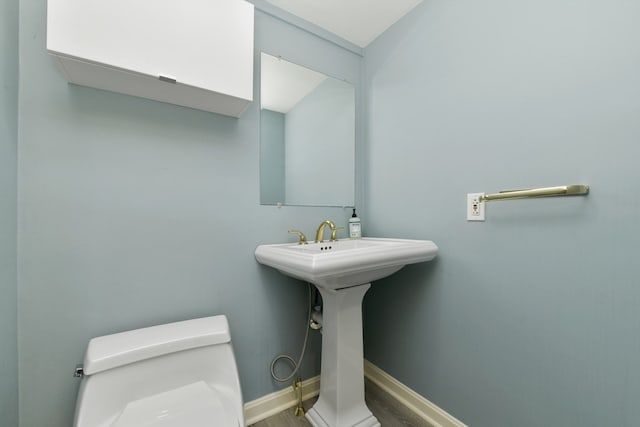 bathroom featuring toilet and wood-type flooring