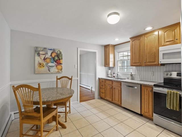 kitchen with light tile patterned floors, decorative backsplash, stainless steel appliances, and a baseboard heating unit