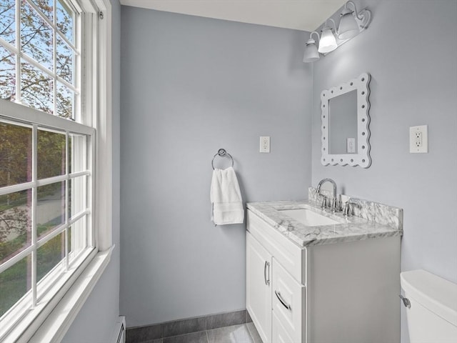 bathroom featuring toilet, baseboards, tile patterned flooring, and vanity