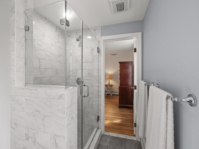 full bathroom featuring visible vents, a baseboard radiator, and a stall shower