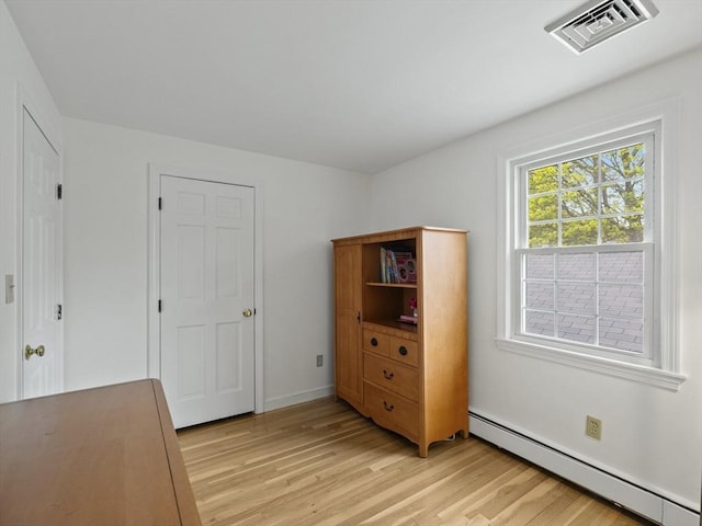 bedroom featuring visible vents, a baseboard radiator, baseboards, and light wood-type flooring