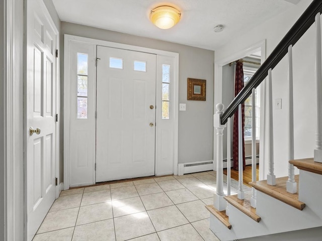 entryway with stairway, light tile patterned floors, plenty of natural light, and baseboards