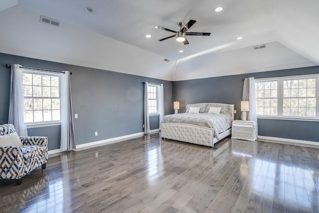 bedroom with multiple windows, wood-type flooring, and lofted ceiling