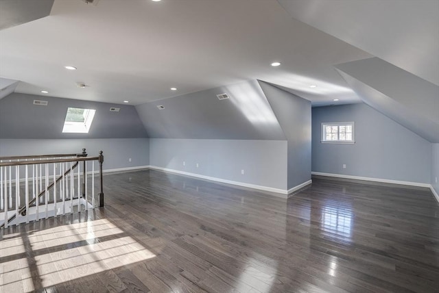 additional living space with dark hardwood / wood-style flooring and lofted ceiling with skylight