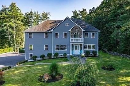 colonial house with a balcony and a front lawn