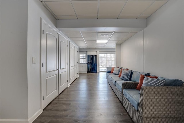 living room featuring a paneled ceiling and dark hardwood / wood-style flooring