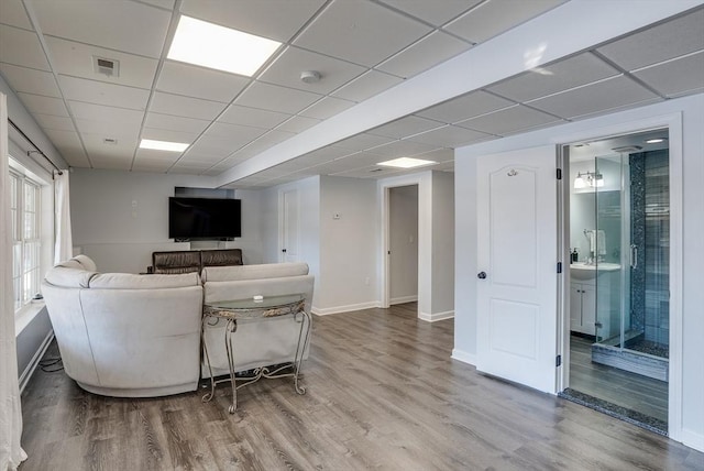 living room featuring hardwood / wood-style floors and a drop ceiling