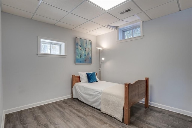 bedroom with a paneled ceiling and wood-type flooring