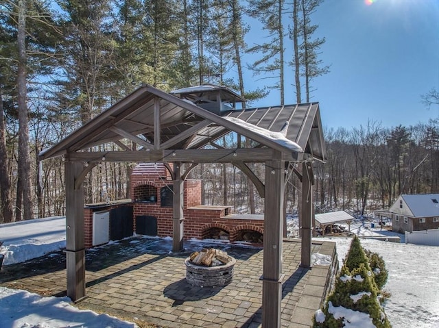 snow covered patio featuring a fire pit