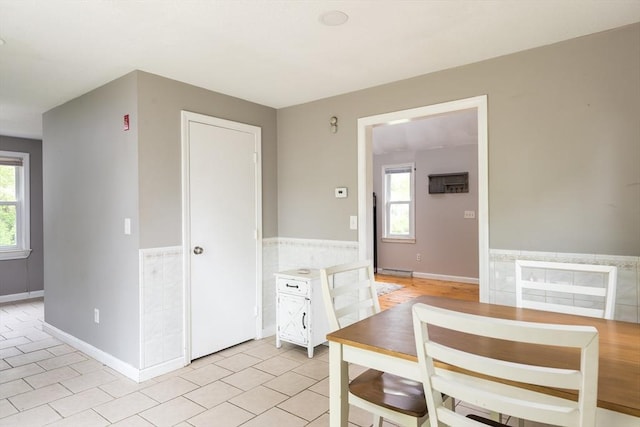 100 Kelley Rd, Barnstable, MA 02601 - dining area with plenty of natural light, light tile patterned floors, a baseboard heating unit, a wainscoted wall, and baseboards