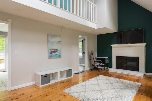100 Kelley Rd, Barnstable, MA 02601 - living area with wood-type flooring, a high ceiling, a fireplace, and baseboards
