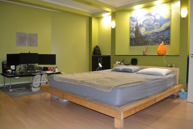 bedroom with wood finished floors, crown molding, and an office area