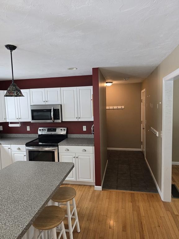 132 Bean Porridge Hill Rd, Westminster, MA 01473 - kitchen featuring appliances with stainless steel finishes, white cabinets, and light wood-type flooring
