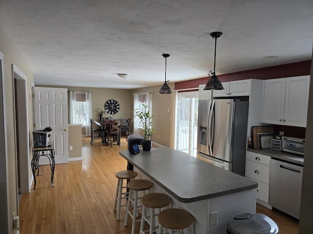 132 Bean Porridge Hill Rd, Westminster, MA 01473 - kitchen featuring appliances with stainless steel finishes, dark countertops, a breakfast bar area, white cabinetry, and light wood-style flooring