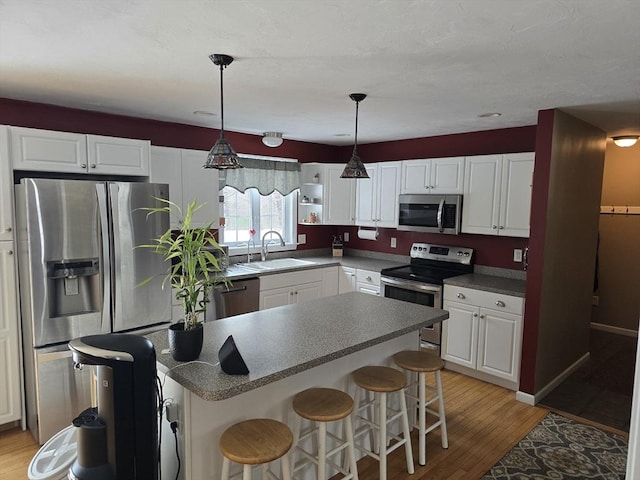 132 Bean Porridge Hill Rd, Westminster, MA 01473 - kitchen featuring appliances with stainless steel finishes, a sink, white cabinetry, a breakfast bar, and light wood-style flooring