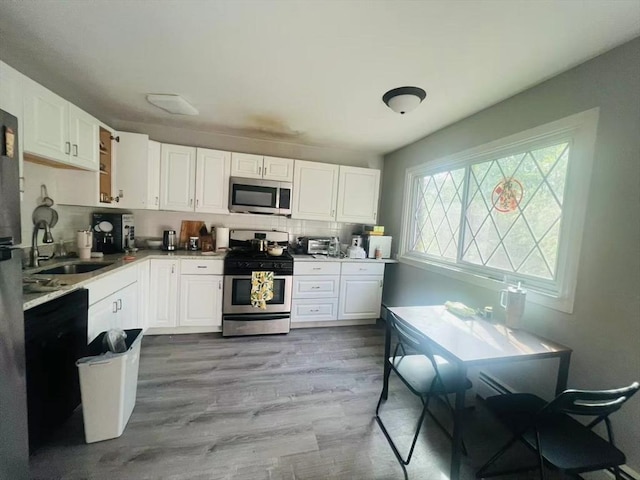3 Fernview Ave Unit 11, North Andover, MA 01845 - kitchen with appliances with stainless steel finishes, wood finished floors, decorative backsplash, and white cabinetry